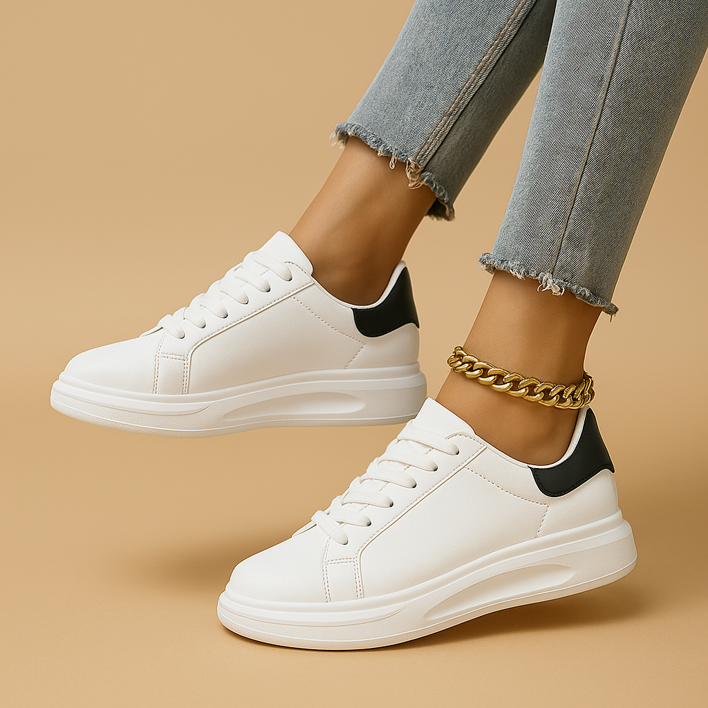 White leather sneakers with minimalist low-top design and cushioned insole, perfect for casual wear and semi-formal outfits.