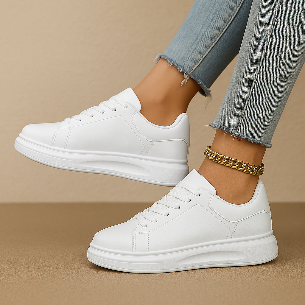 White leather sneakers with minimalist low-top design and cushioned insole, perfect for casual wear and semi-formal outfits.