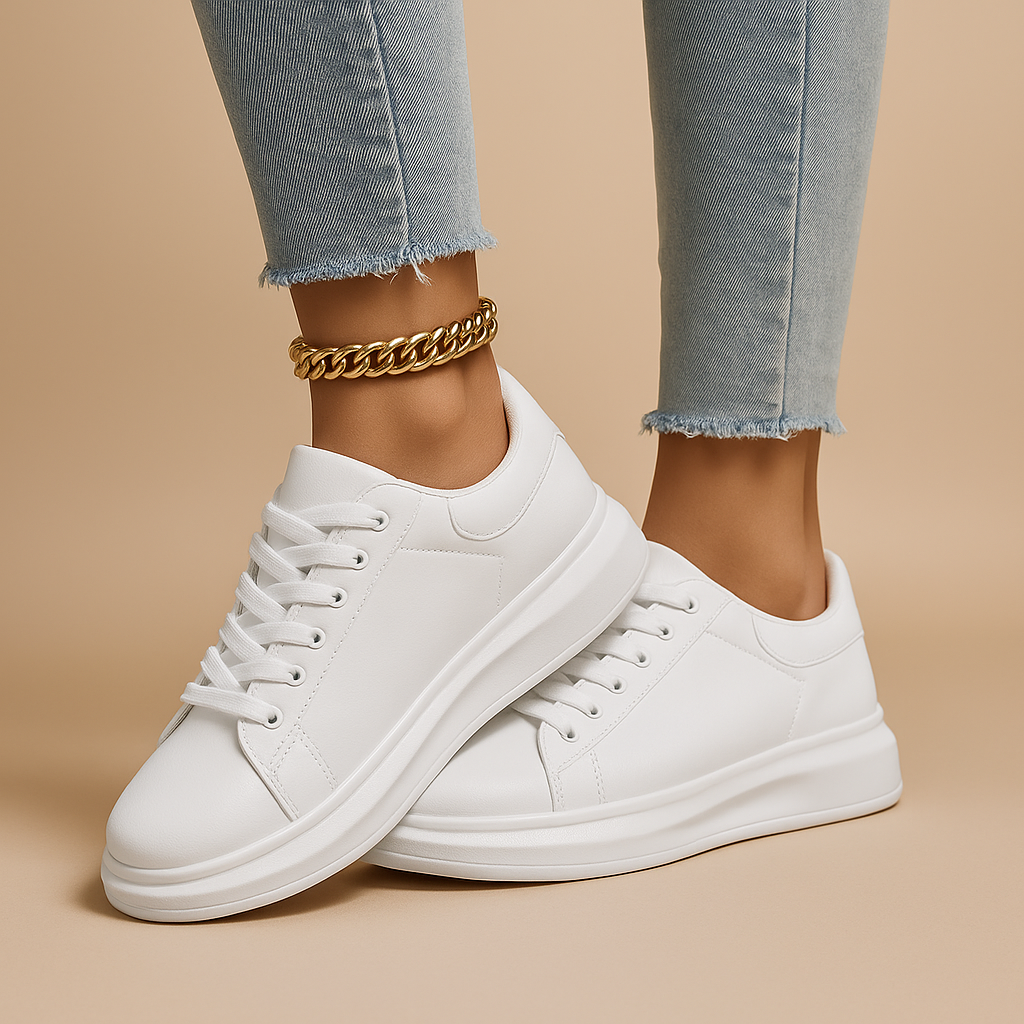 White leather sneakers with minimalist low-top design and cushioned insole, perfect for casual wear and semi-formal outfits.