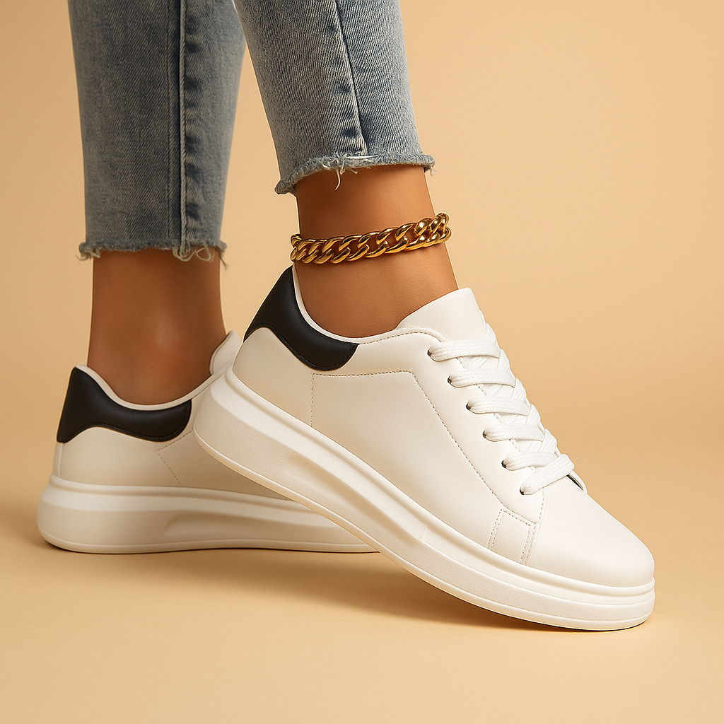 White leather sneakers with minimalist low-top design and cushioned insole, perfect for casual wear and semi-formal outfits.