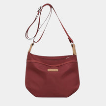 Anti-theft crossbody travel bag for women in waterproof fabric with wide strap, top zipper, and multiple compartments for secure travel.